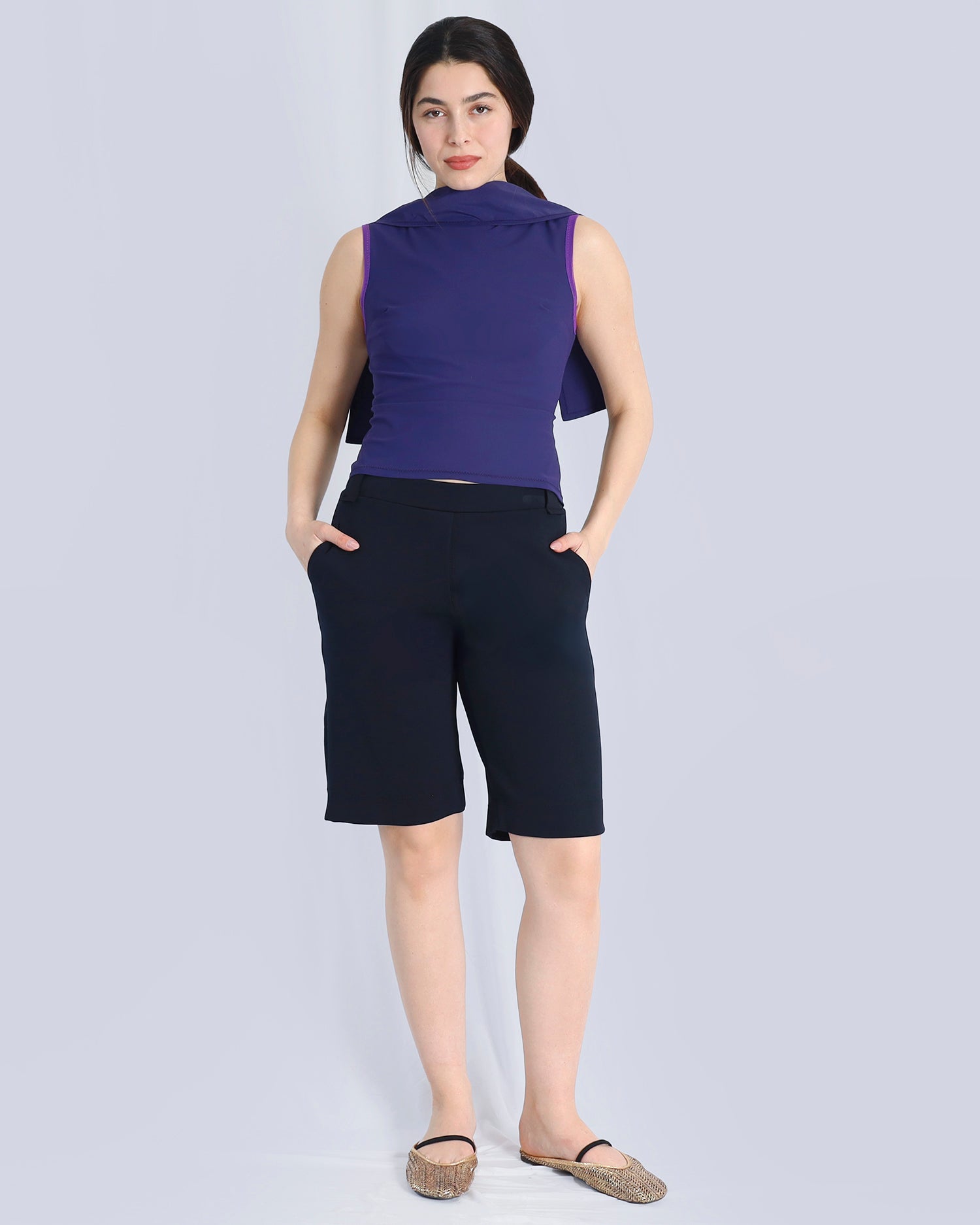 Woman wearing a purple sleeveless top and black shorts on a white background. Maison Marie Saint Pierre | Pants | DELPH | Black | Top | PAYTON | Indigo 