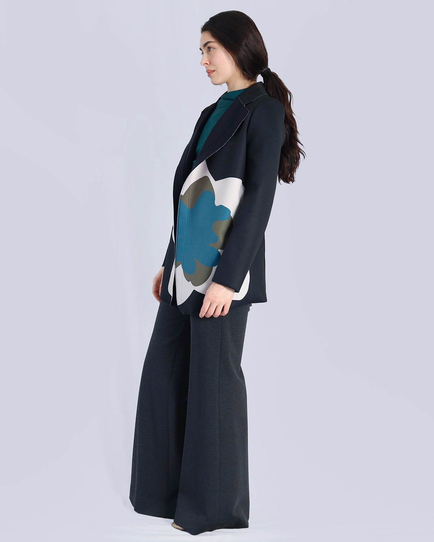 Woman wearing a dark blue outfit with a large abstract floral design on a light gray background. Maison Marie Saint Pierre | Pants | AVALON2 | GMI | Jacket | PAOLO2 | Black Wisteria Macro | Top | PAYTON | HUN