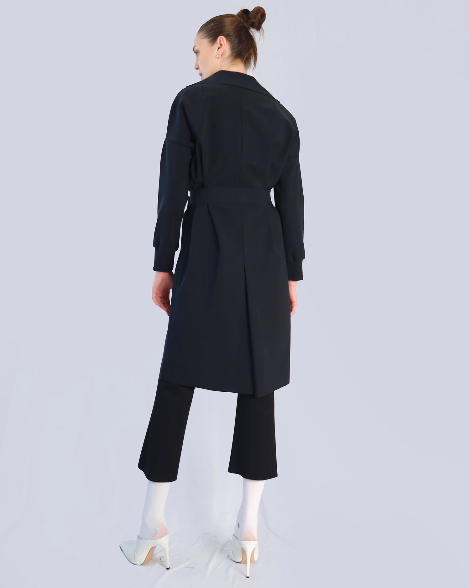 Woman wearing a black coat and pants on a light gray background. Maison Marie Saint Pierre | Coat | PELLINAME | ANT | Pants | PALLAS | Black | Top | PALRAIR | Petrol