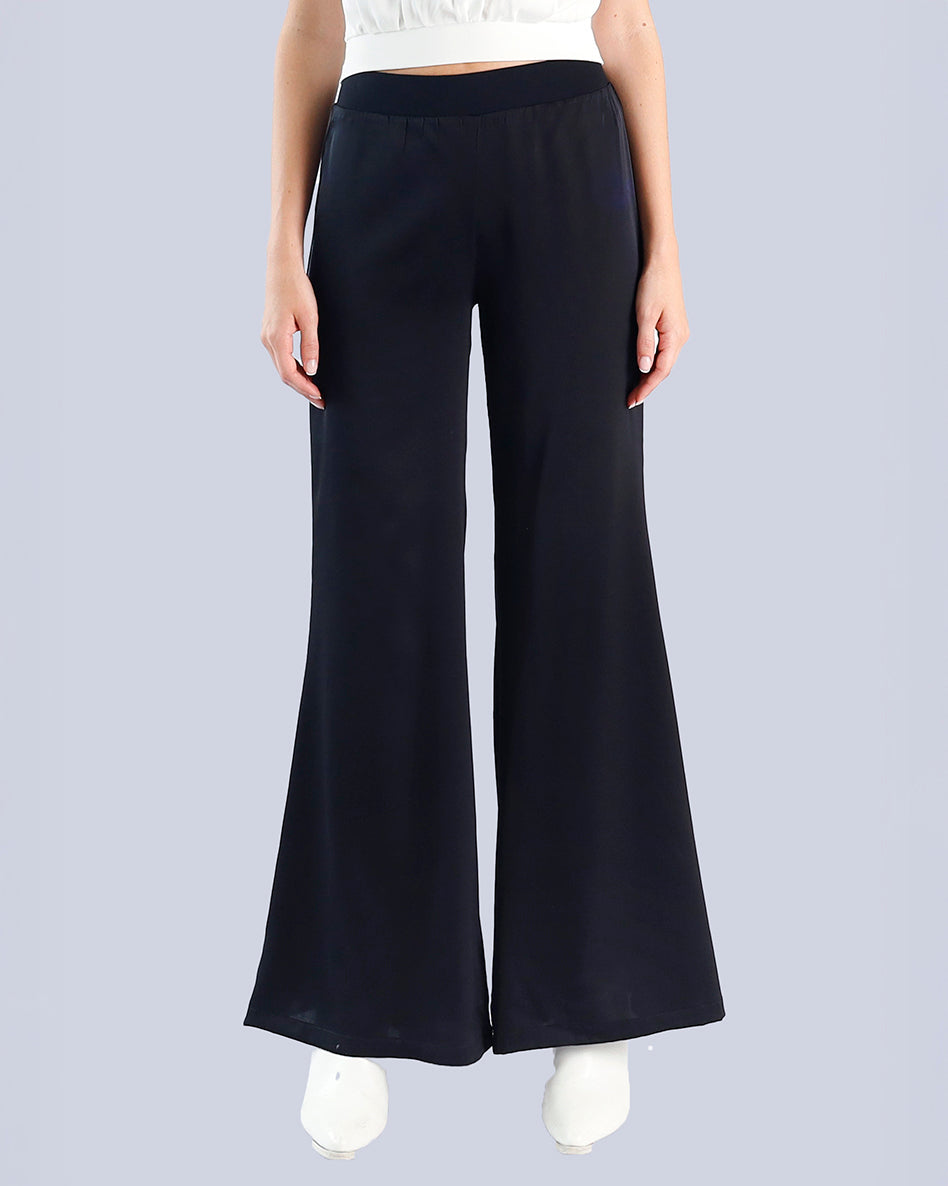 Black wide-leg pants worn by a person on a light gray background. Maison Marie Saint Pierre | Pants | PAMELA | Black 