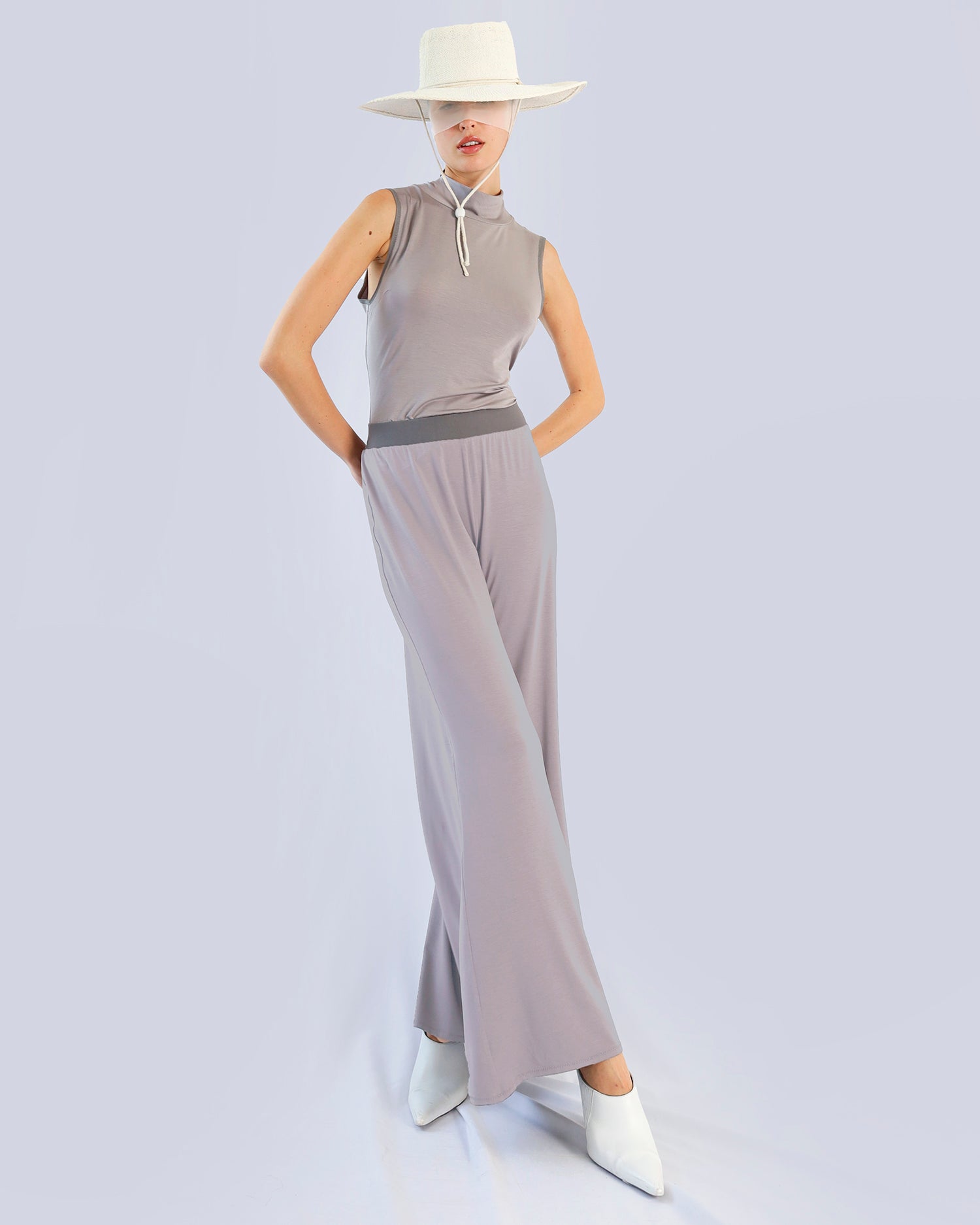 Woman wearing a sleeveless top and wide-leg pants with a white hat on a light gray backgroundMaison Marie Saint Pierre | Pants | PAMELINE2 | Seal | Top | PAYTON2 | Seal 