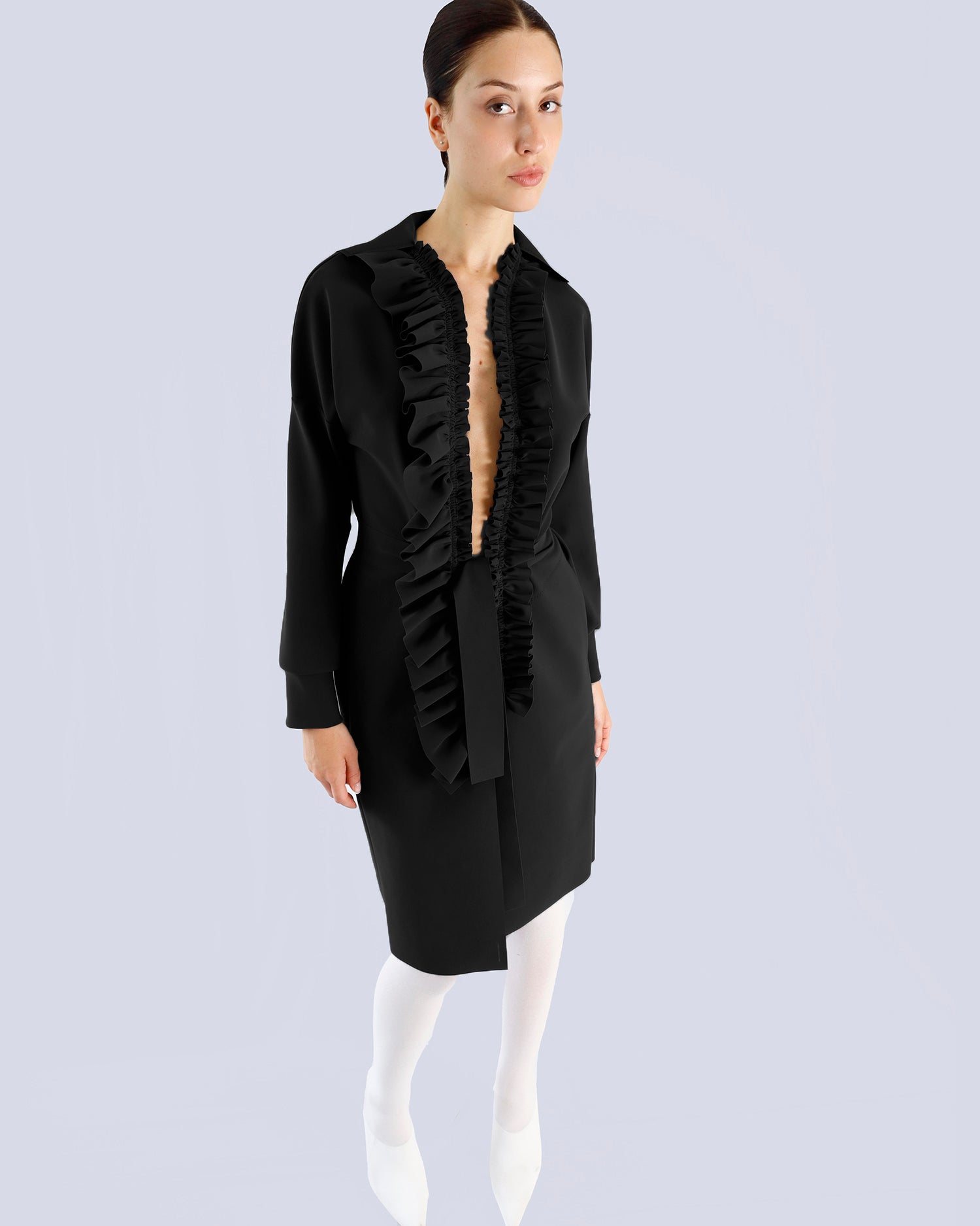 Woman wearing a black dress with ruffled details on a light gray background. Maison Marie Saint Pierre | Coat | PELLINAME | ANT | Pants | PALLAS | Black