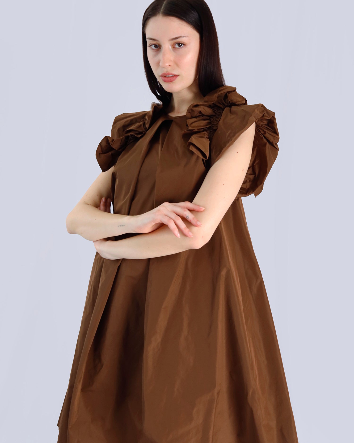 Woman wearing a brown dress with ruffled sleeves against a light gray background. Maison Marie Saint Pierre | Dress | PAVOLINE | DUM 
