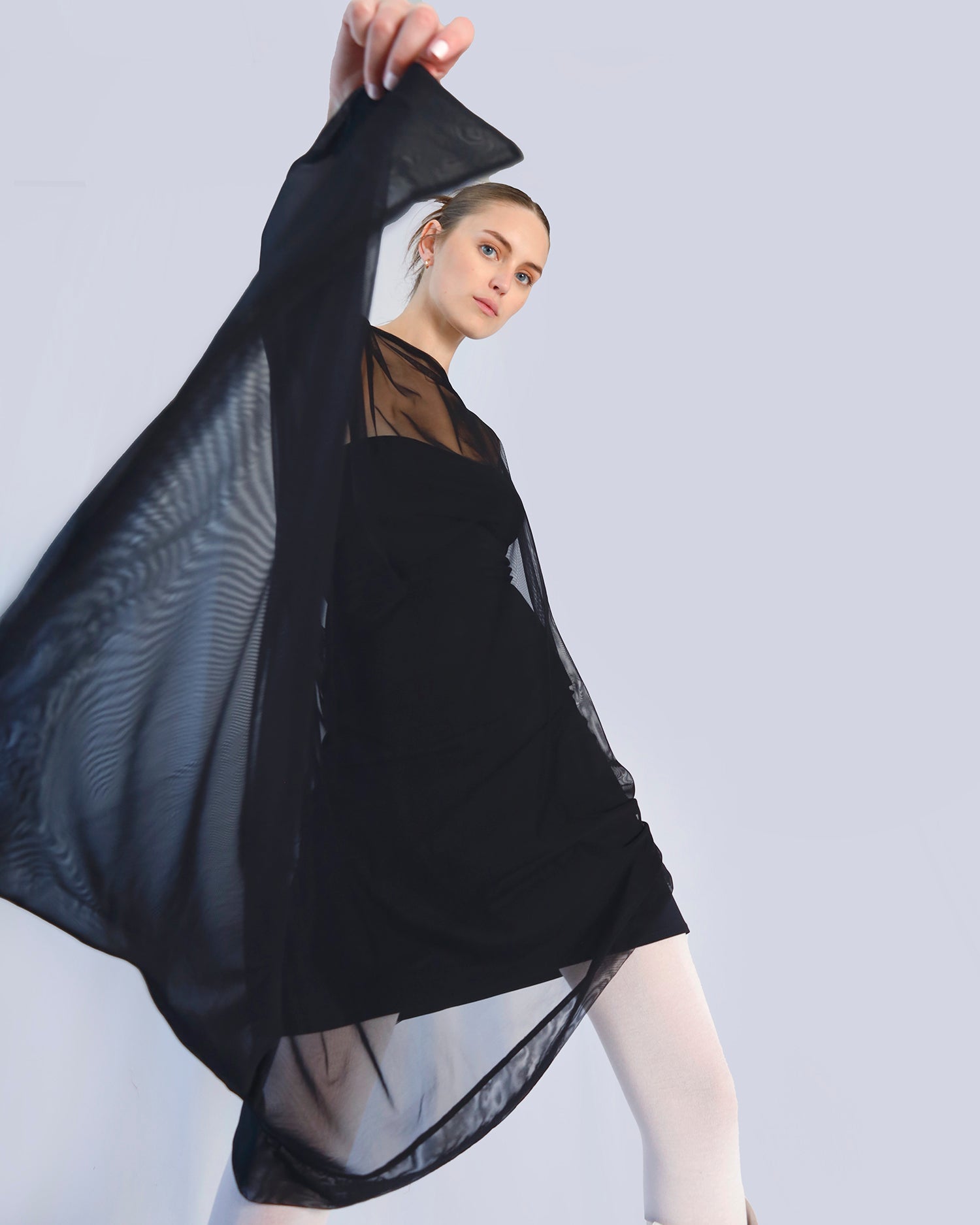 Woman holding a black sheer fabric against a light gray background. Maison Marie Saint Pierre | Dress | PHASMINA | Black