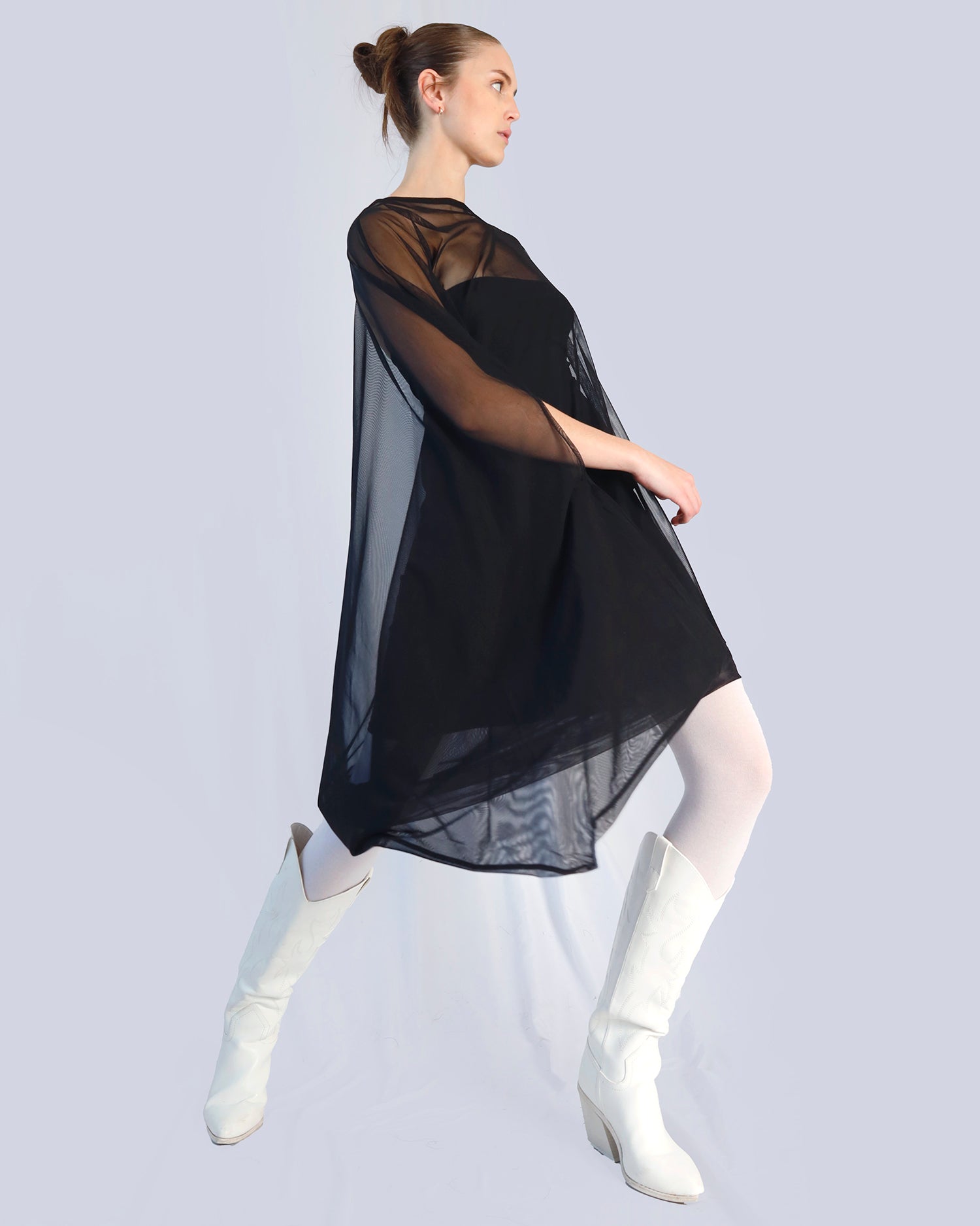Woman wearing a black sheer dress with white boots on a light gray background. Maison Marie Saint Pierre | Dress | PHASMINA | Black