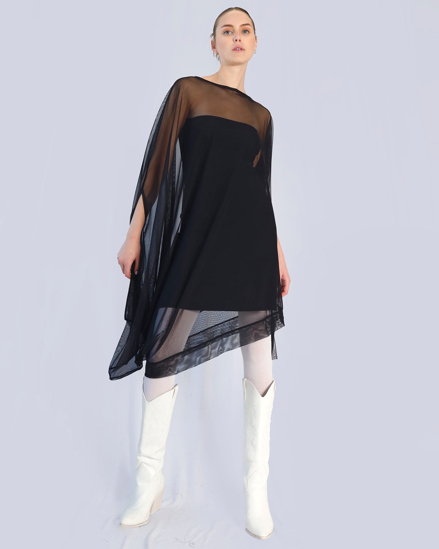 Woman wearing a black dress with sheer overlay and white boots on a light gray background. Maison Marie Saint Pierre | Dress | PHASMINA | Black 